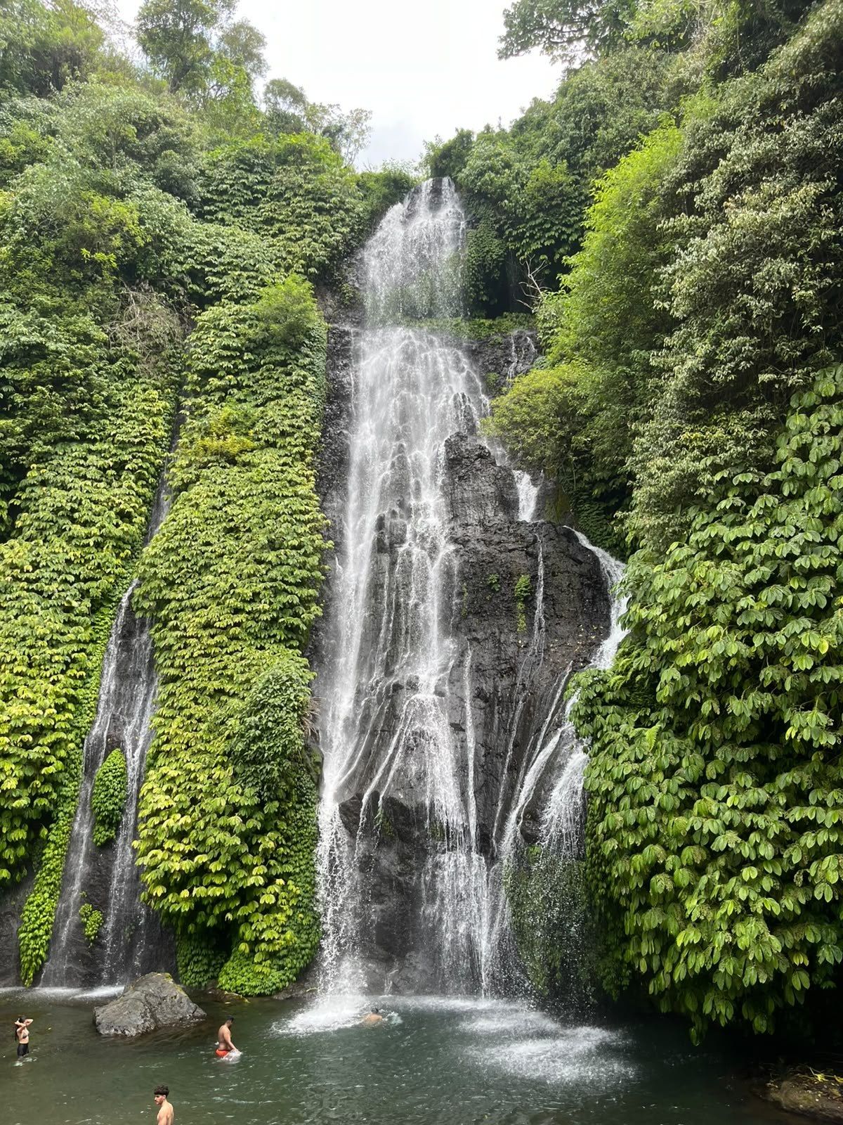 The main cascade at Banyumala with swimmers in the pool below