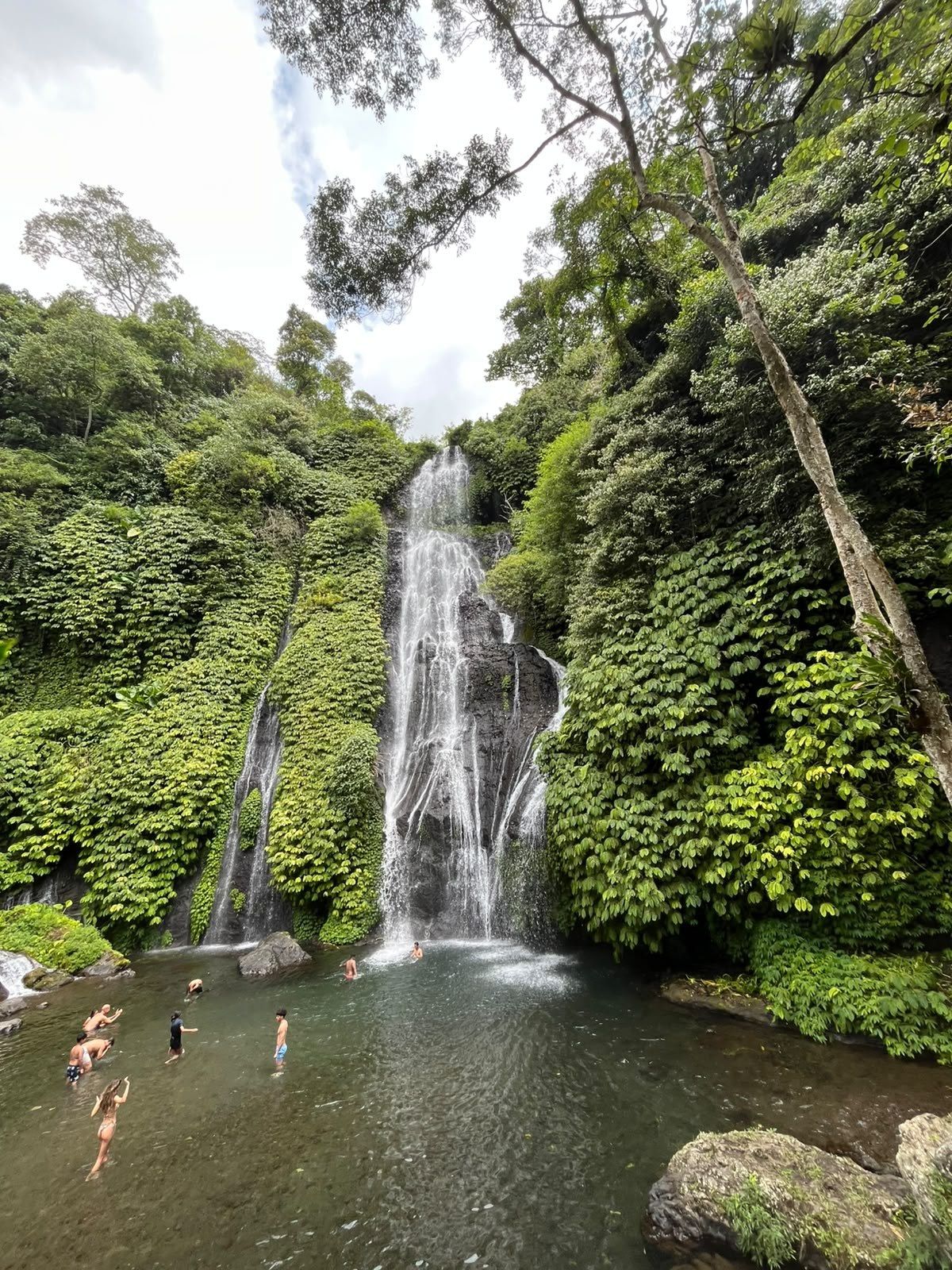 Hikers swimming in the pool at Banyumala waterfall