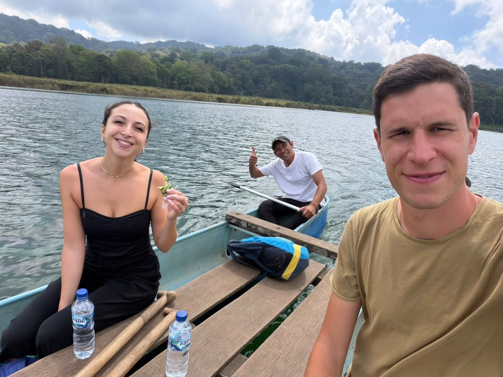 Guests smiling in a canoe on the lake with their guide behind them