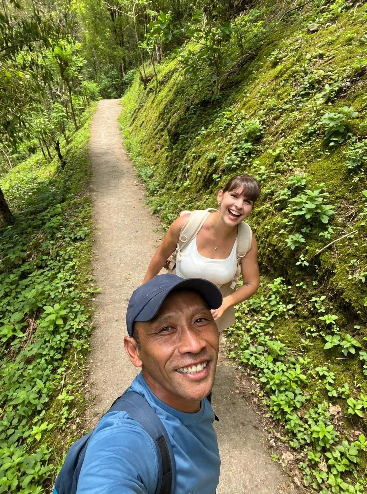 Ketut Darma taking a selfie with a guest on a forest trail near Munduk